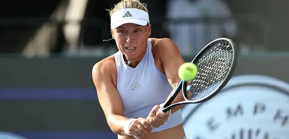 Jugadora de tenis golpeando la pelota en un partido