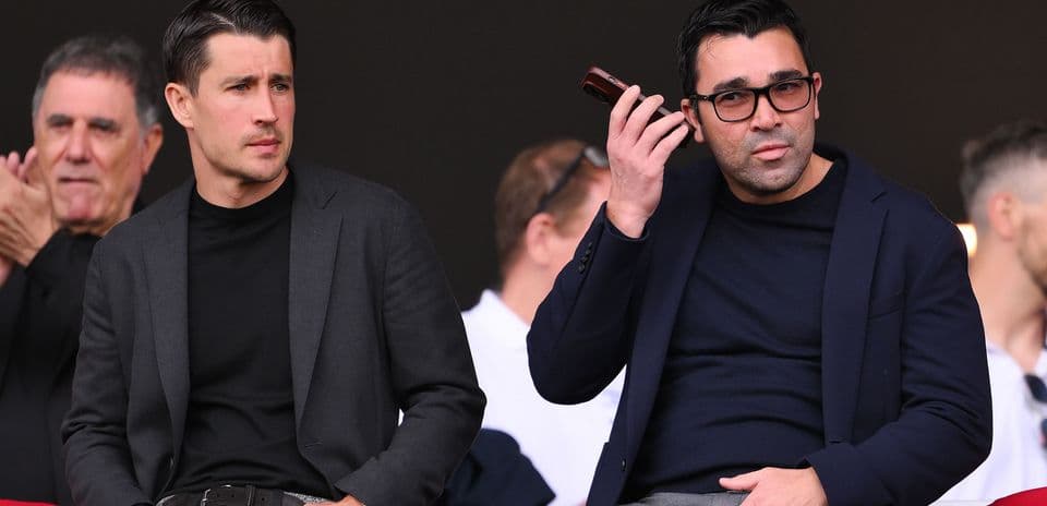 Dos hombres en un palco durante un evento deportivo