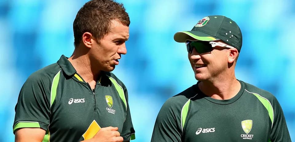 Dos jugadores de cricket conversando durante el entrenamiento