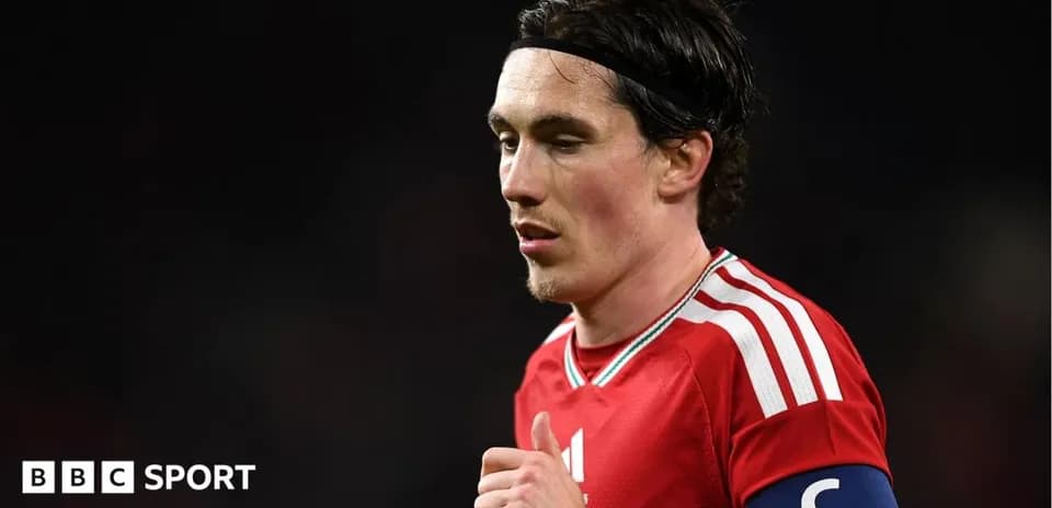 Jugador con banda de capitán en camiseta roja