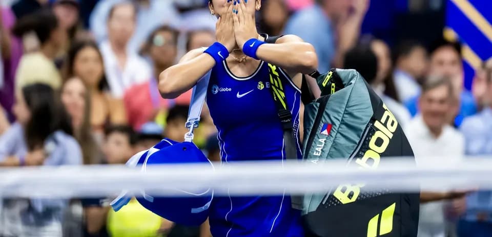 Jugadora de tenis celebrando con mochila en la mano