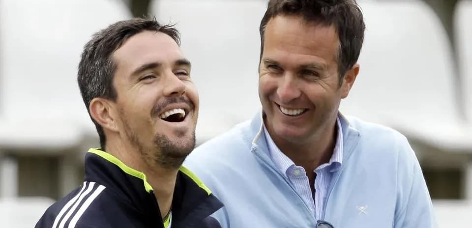 Dos hombres sonriendo en un campo de cricket