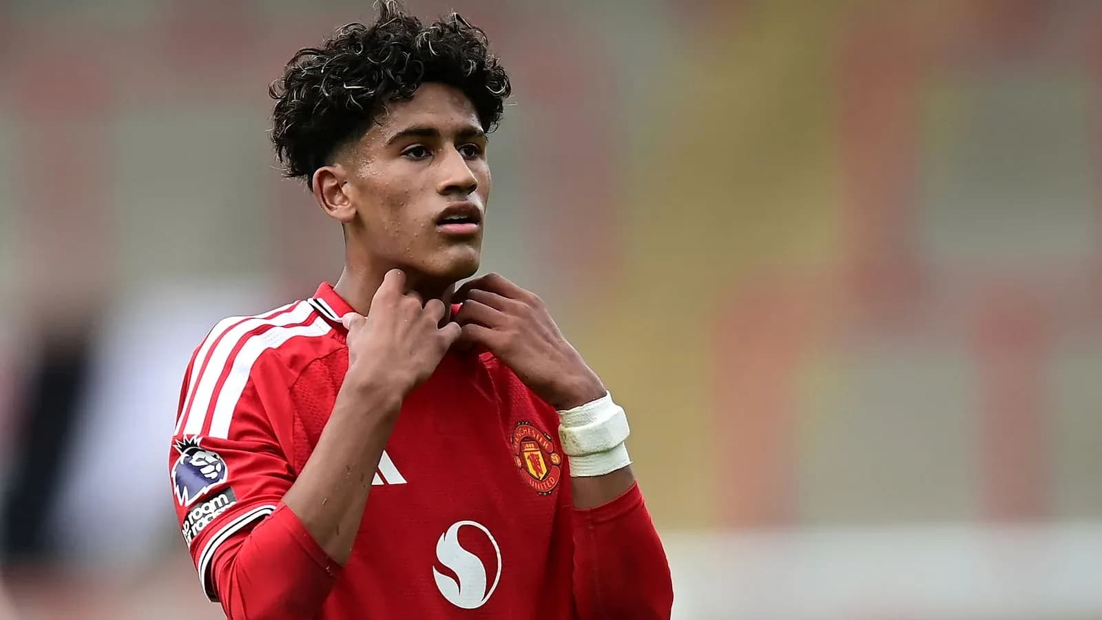 Jugador de Manchester United ajustándose el cuello de la camiseta