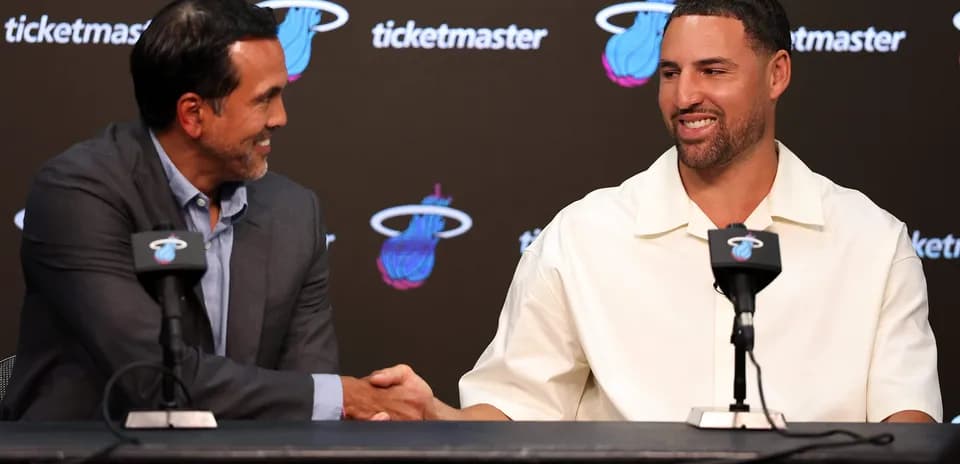 Entrenador y jugador saludándose en conferencia de prensa