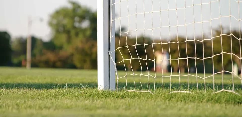 Portería de fútbol con césped y fondo difuso