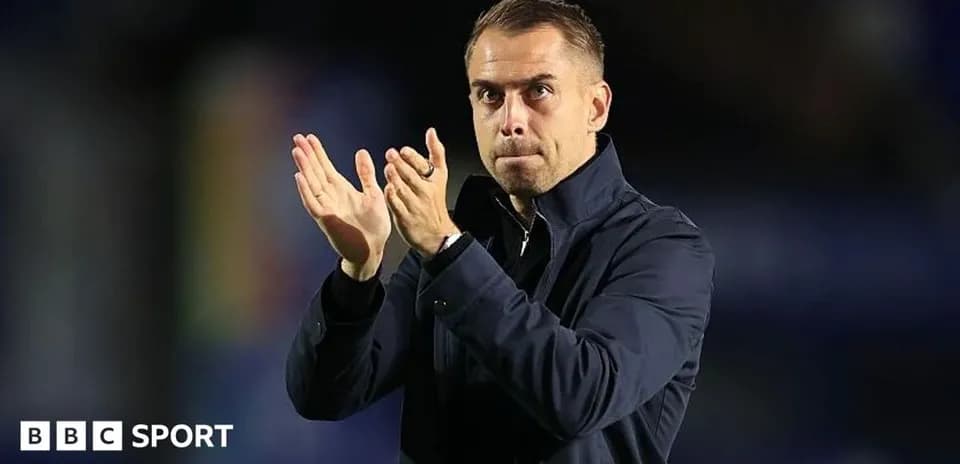 Entrenador aplaudiendo desde la banda del campo