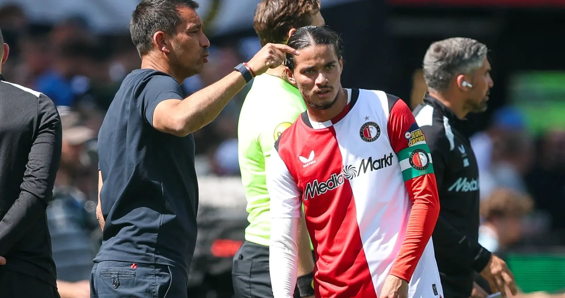 Entrenador instruyendo a jugador en la banda