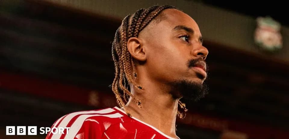 Jugador con camiseta roja en estadio de fútbol
