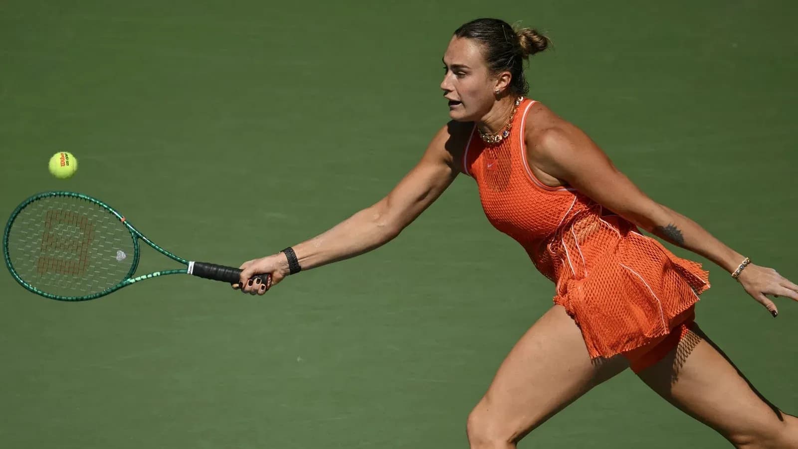Jugadora golpeando una pelota de tenis en la cancha