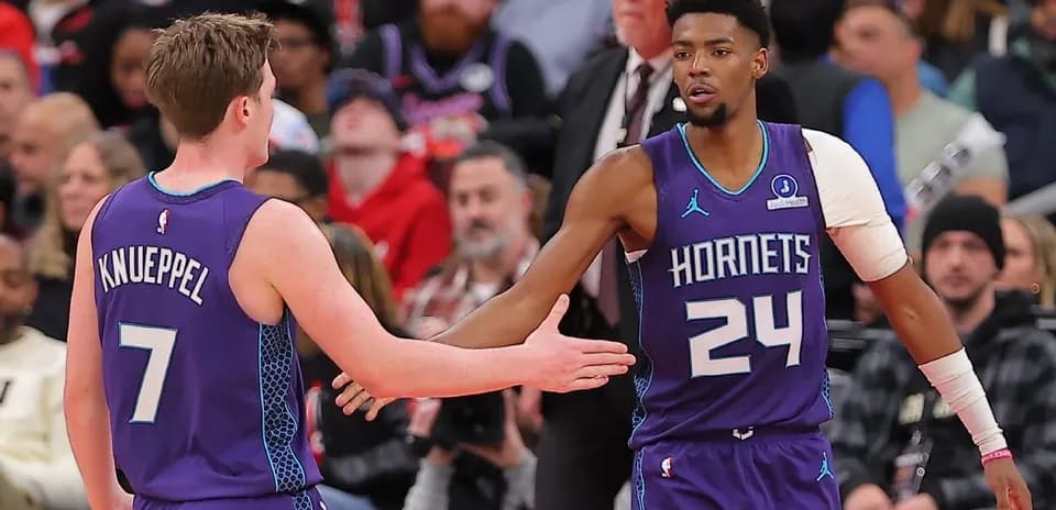 Jugadores de los Hornets chocando manos en la cancha