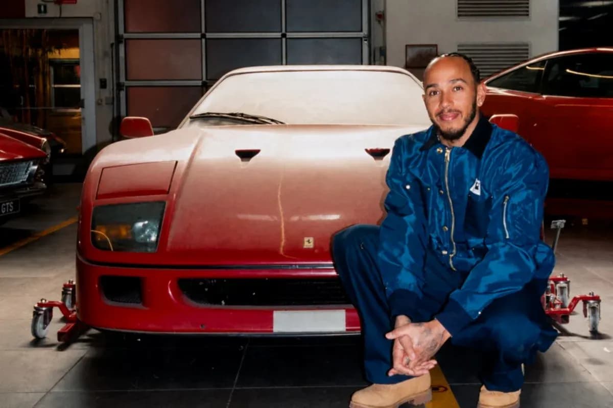 Hombre posando junto a un Ferrari rojo en taller Hombre posando junto a un Ferrari rojo en taller