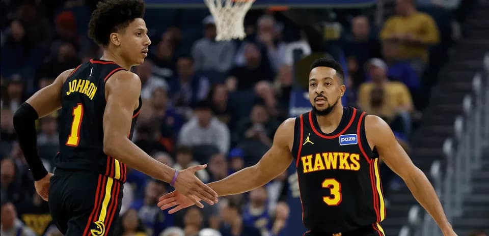 Jugadores de los Hawks chocando las manos en la cancha