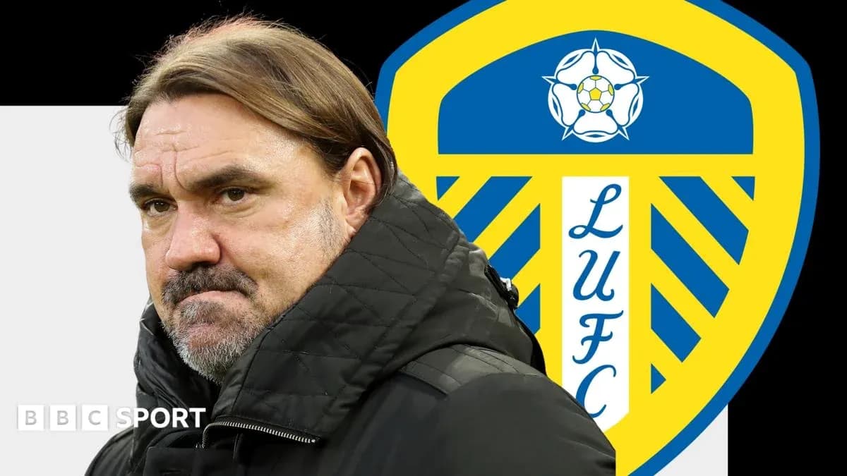 Entrenador con chaqueta negra frente al escudo de Leeds United
