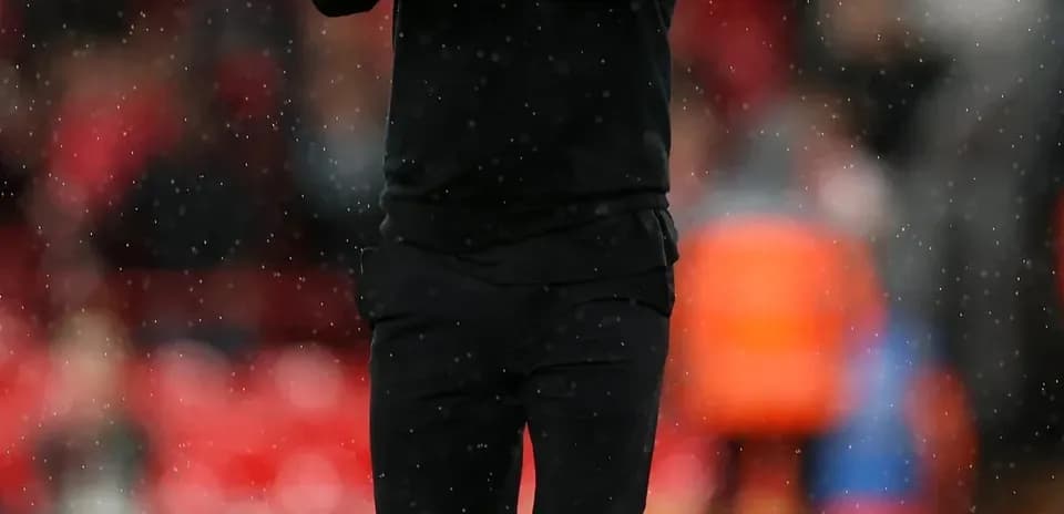 Entrenador aplaudiendo en el campo de fútbol