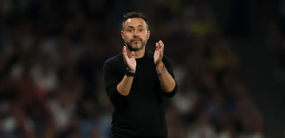 Entrenador aplaudiendo durante el partido en estadio