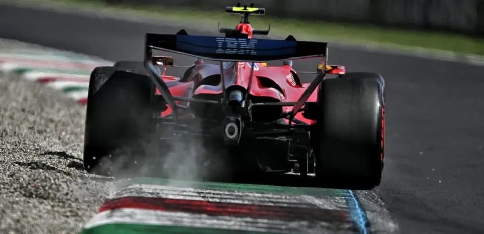 Coche de Fórmula 1 en curva con humo en pista