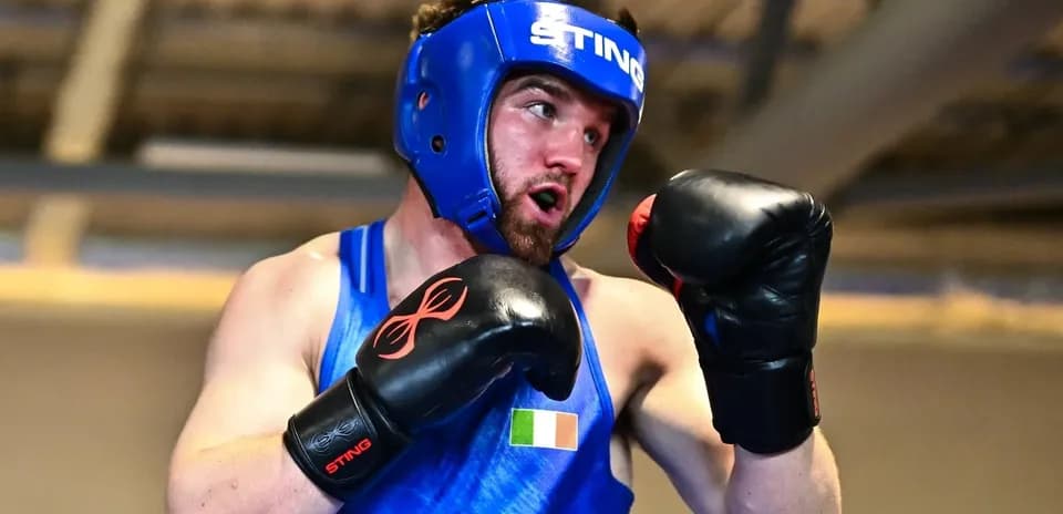 Boxeador entrenando con guantes y casco en gimnasio