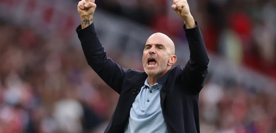 Entrenador celebrando con los puños en alto