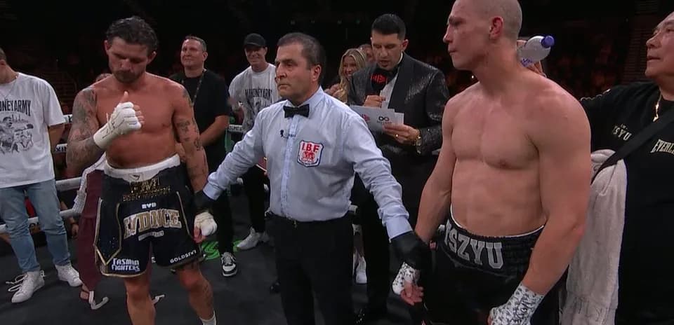 Boxeadores y árbitro en el ring tras pelea