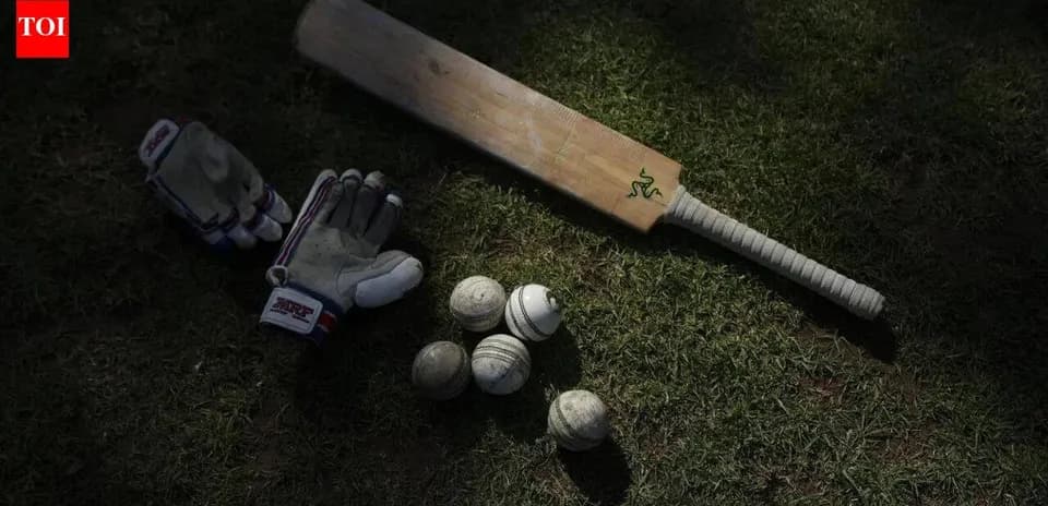 Bate de cricket, guantes y pelotas en el suelo