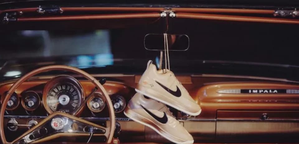 Zapatillas Nike colgadas en el interior de un coche