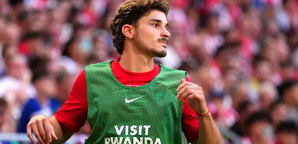 Jugador en la banca con chaleco verde durante partido