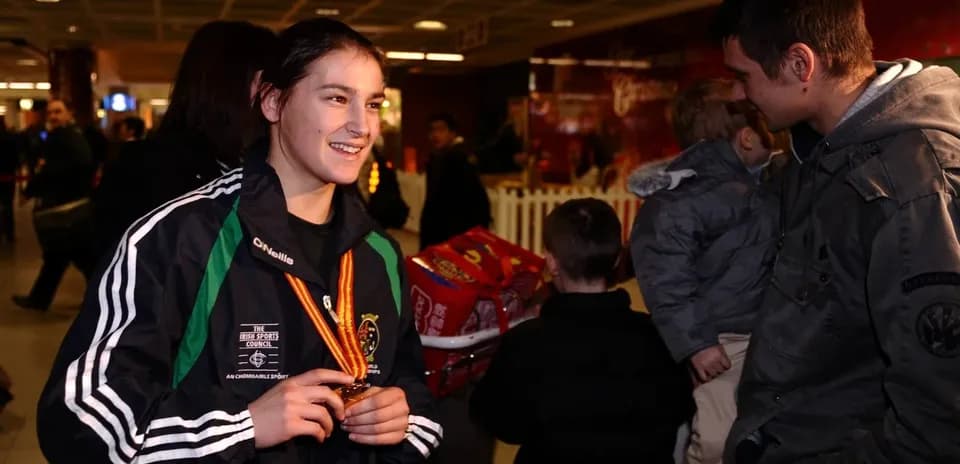 Atleta con medalla sonriendo en un aeropuerto
