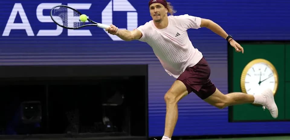 Jugador de tenis alcanzando la pelota en la cancha