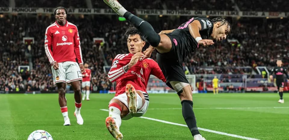 Jugador de Manchester United derribando a un oponente