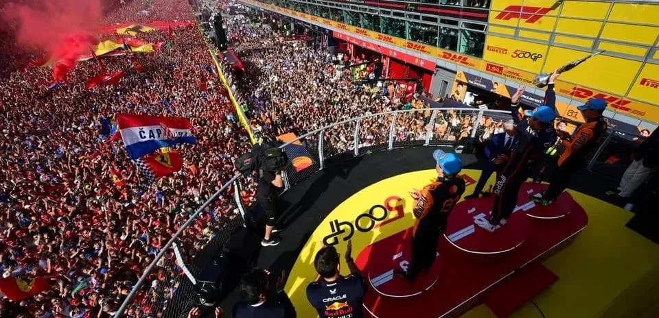 Podio de premiación con pilotos y multitud celebrando