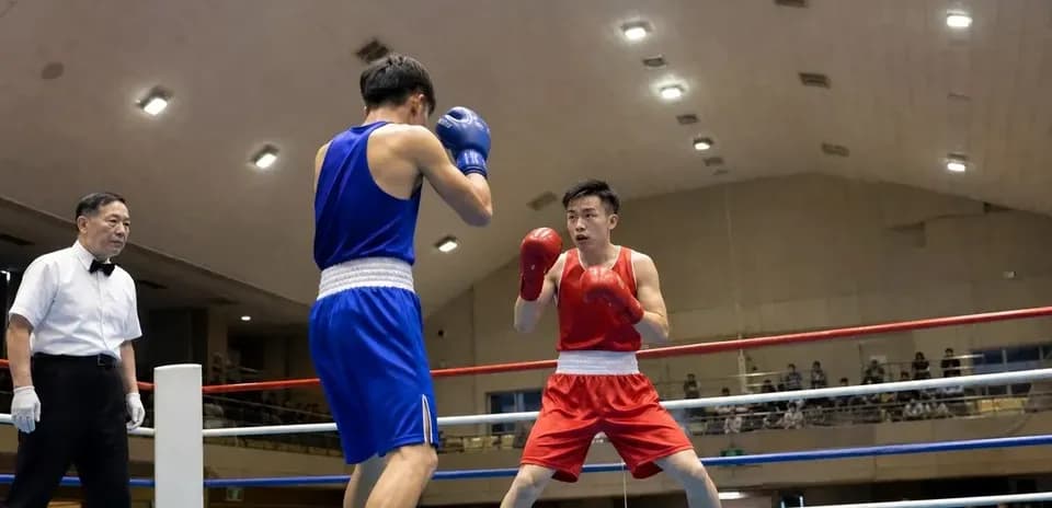 Dos boxeadores compitiendo en un ring de boxeo