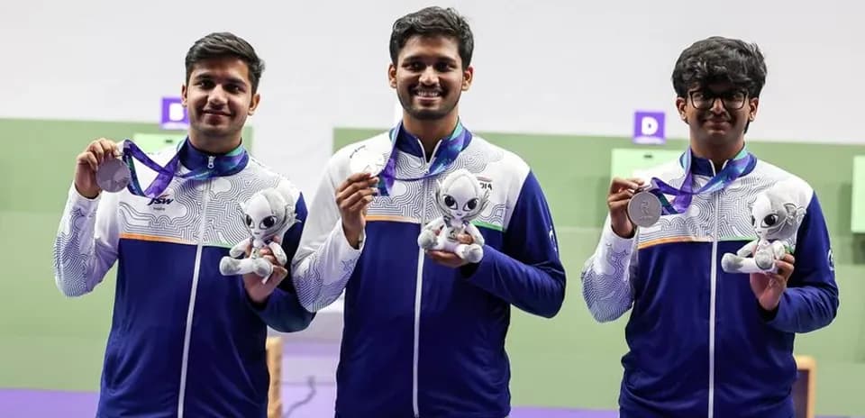 Tres atletas sosteniendo medallas y peluches en podio