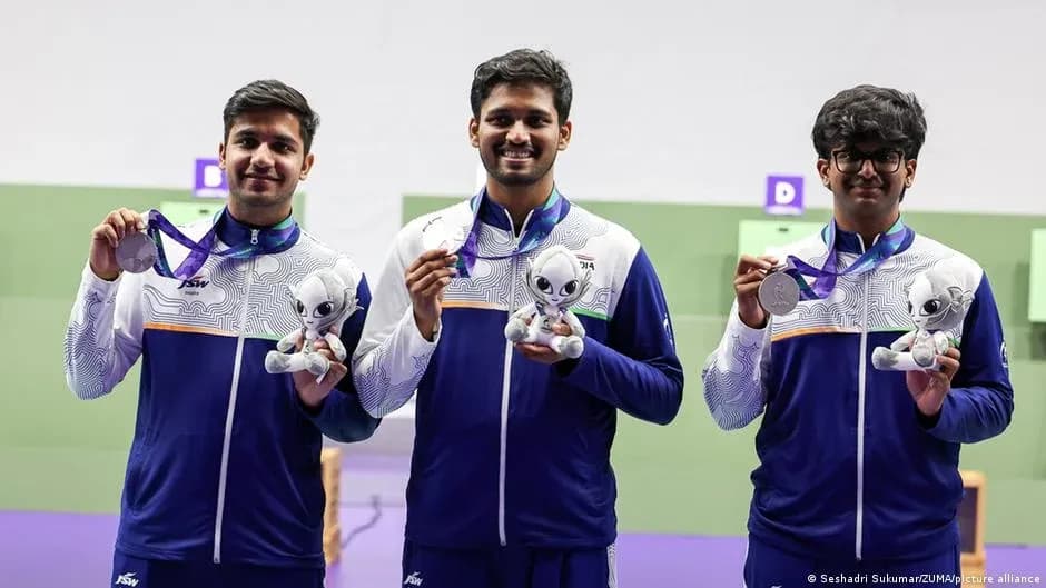 Tres atletas sosteniendo medallas y peluches en podio