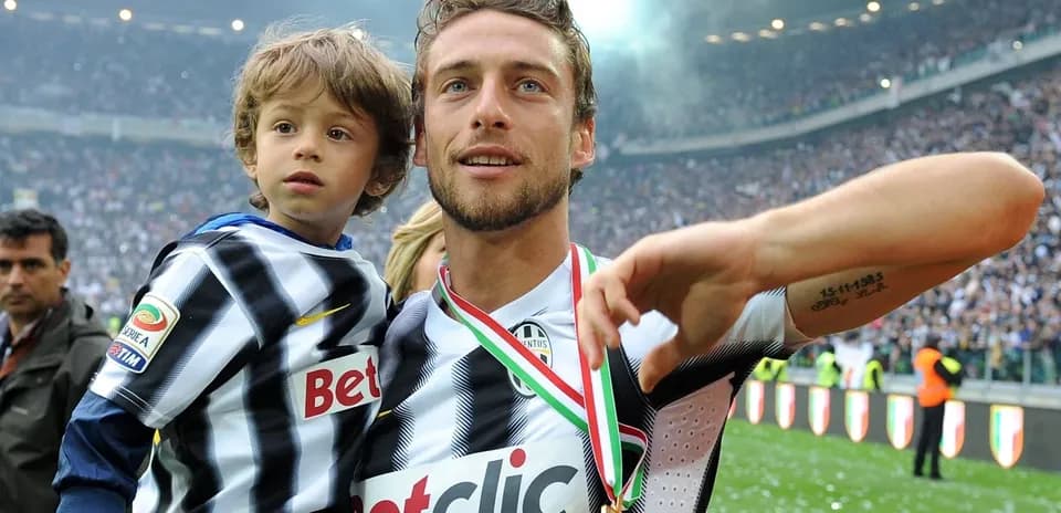 Jugador de fútbol sosteniendo a un niño en el campo