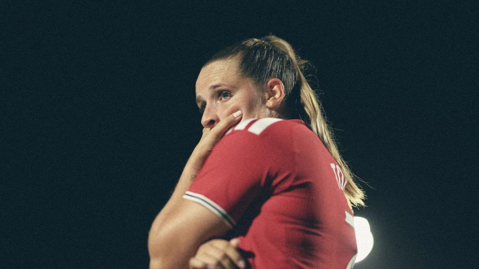 Jugadora en camiseta roja con expresión pensativa