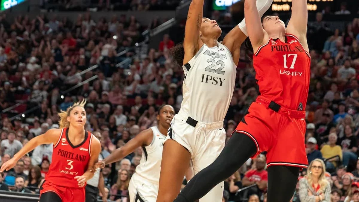 Jugadora intentando bloquear tiro en partido de baloncesto