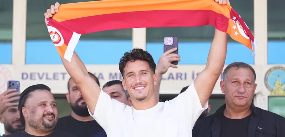 Jugador sosteniendo una bufanda de Galatasaray en evento