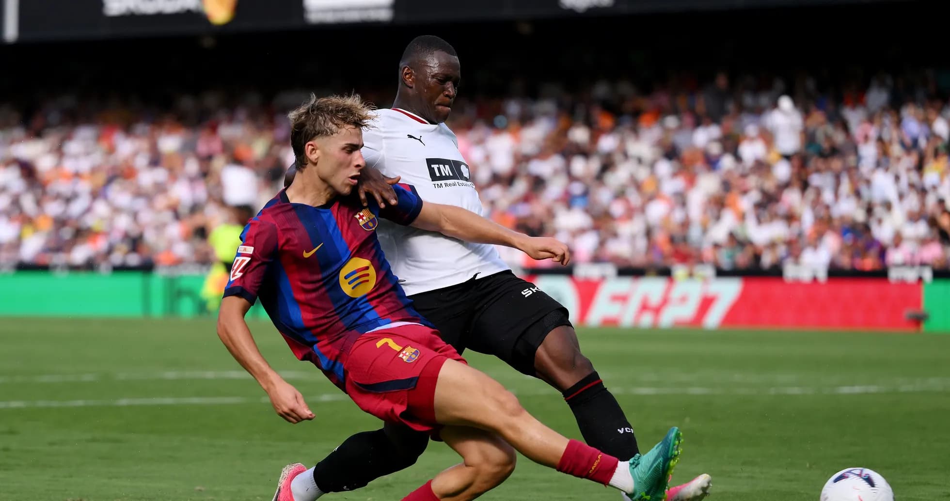 Jugador de Barcelona luchando por el balón con rival