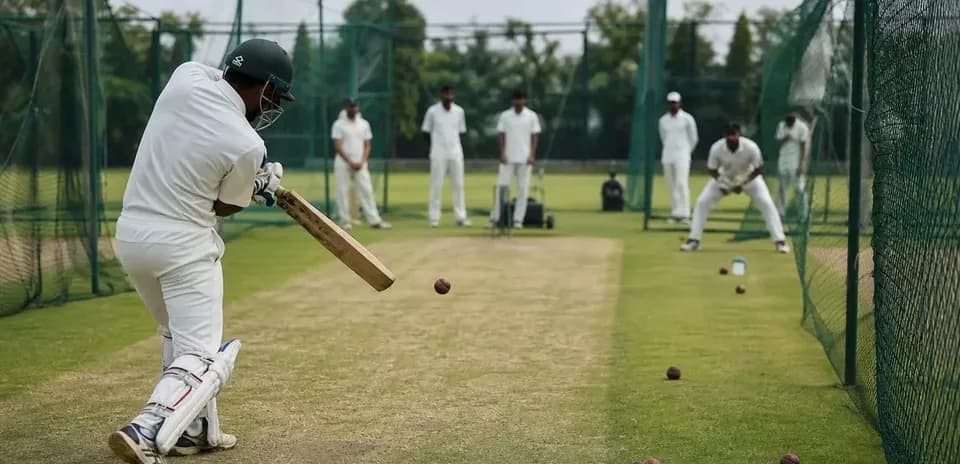 Bateador practicando en campo de cricket con compañeros