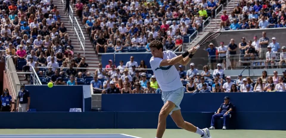 Jugador de tenis golpeando la pelota en partido