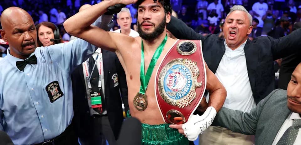 Boxeador celebrando con cinturón en el ring