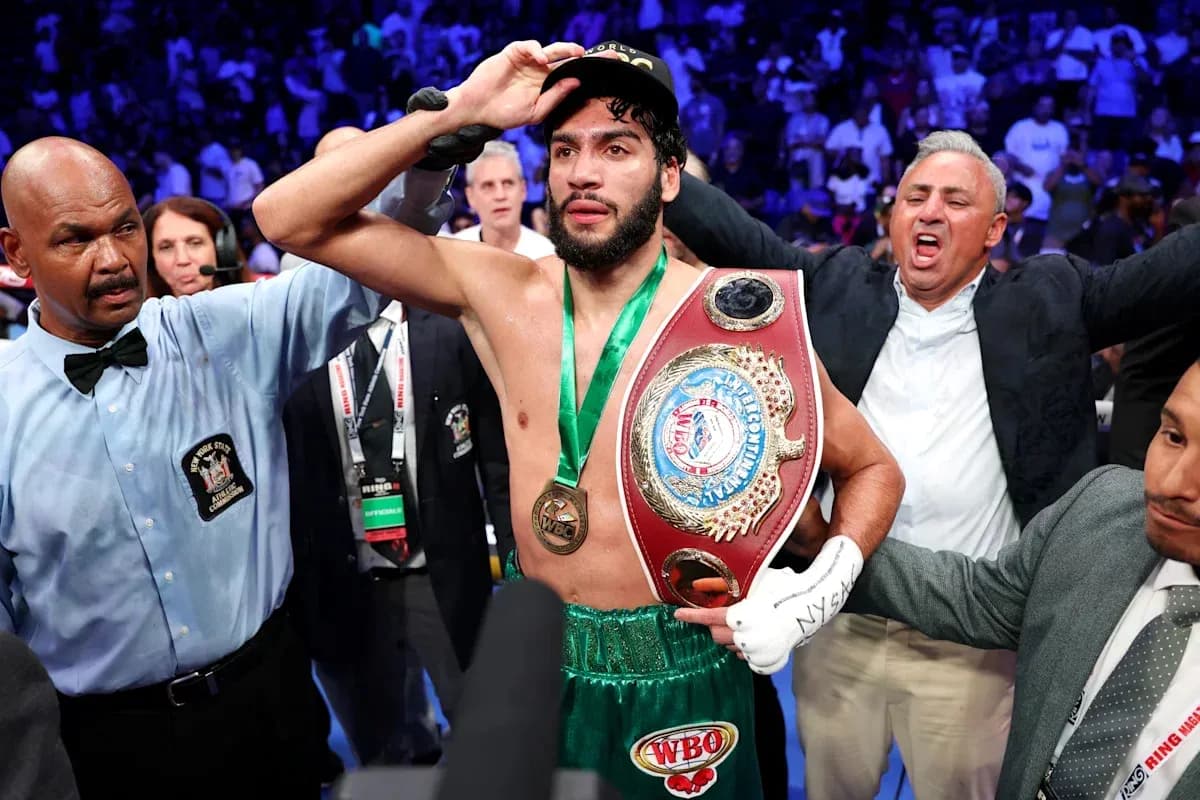 Boxeador celebrando con cinturón en el ring