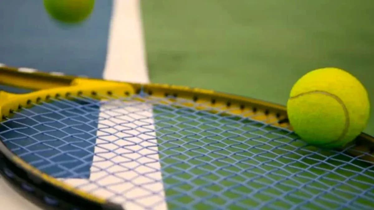 Pelota de tenis sobre una raqueta amarilla