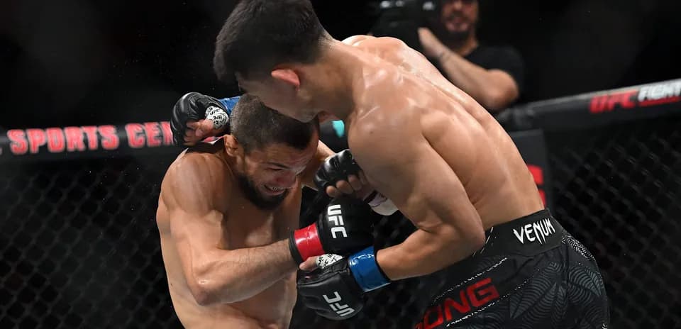 Luchadores intercambiando golpes en combate de MMA