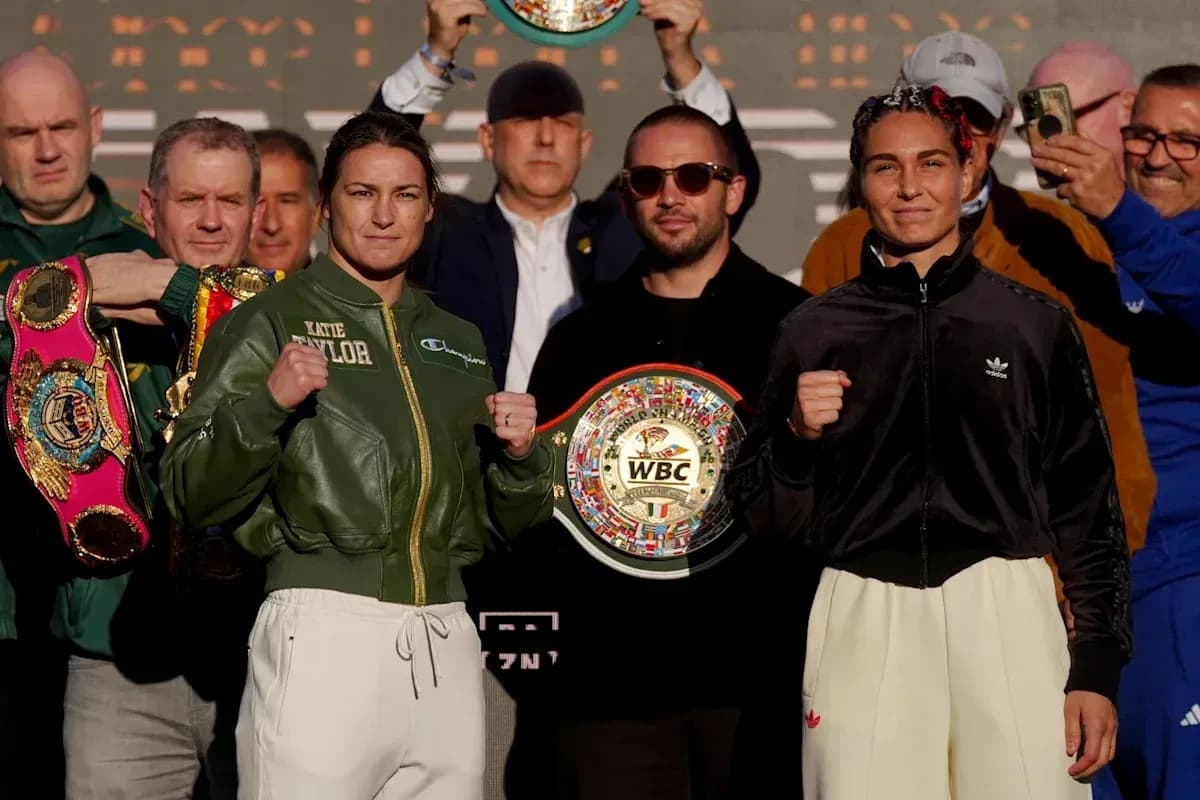 Katie Taylor y rival posando con cinturones de boxeo