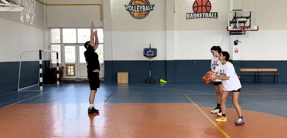 Entrenador enseñando tiro en cancha de baloncesto
