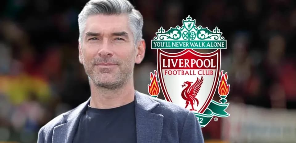 Hombre posando frente al escudo de Liverpool FC