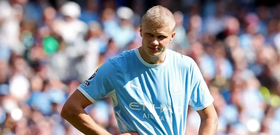 Jugador de Manchester City con camiseta azul en el campo
