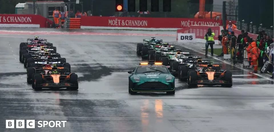 Coches de Fórmula 1 alineados en pista mojada