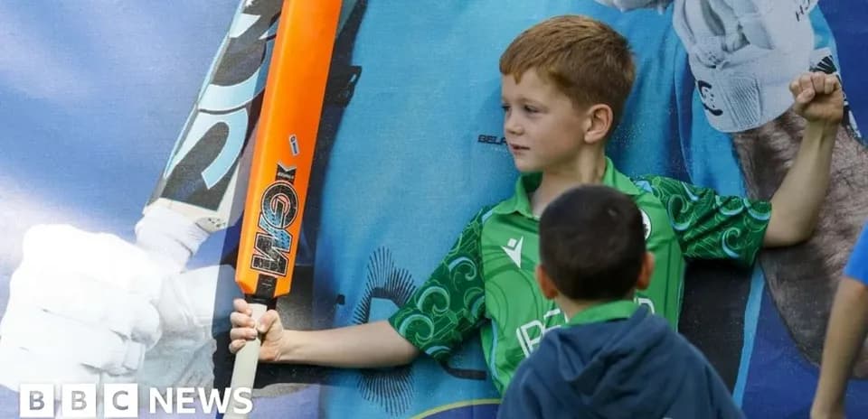 Niño sosteniendo un bate de cricket frente a mural